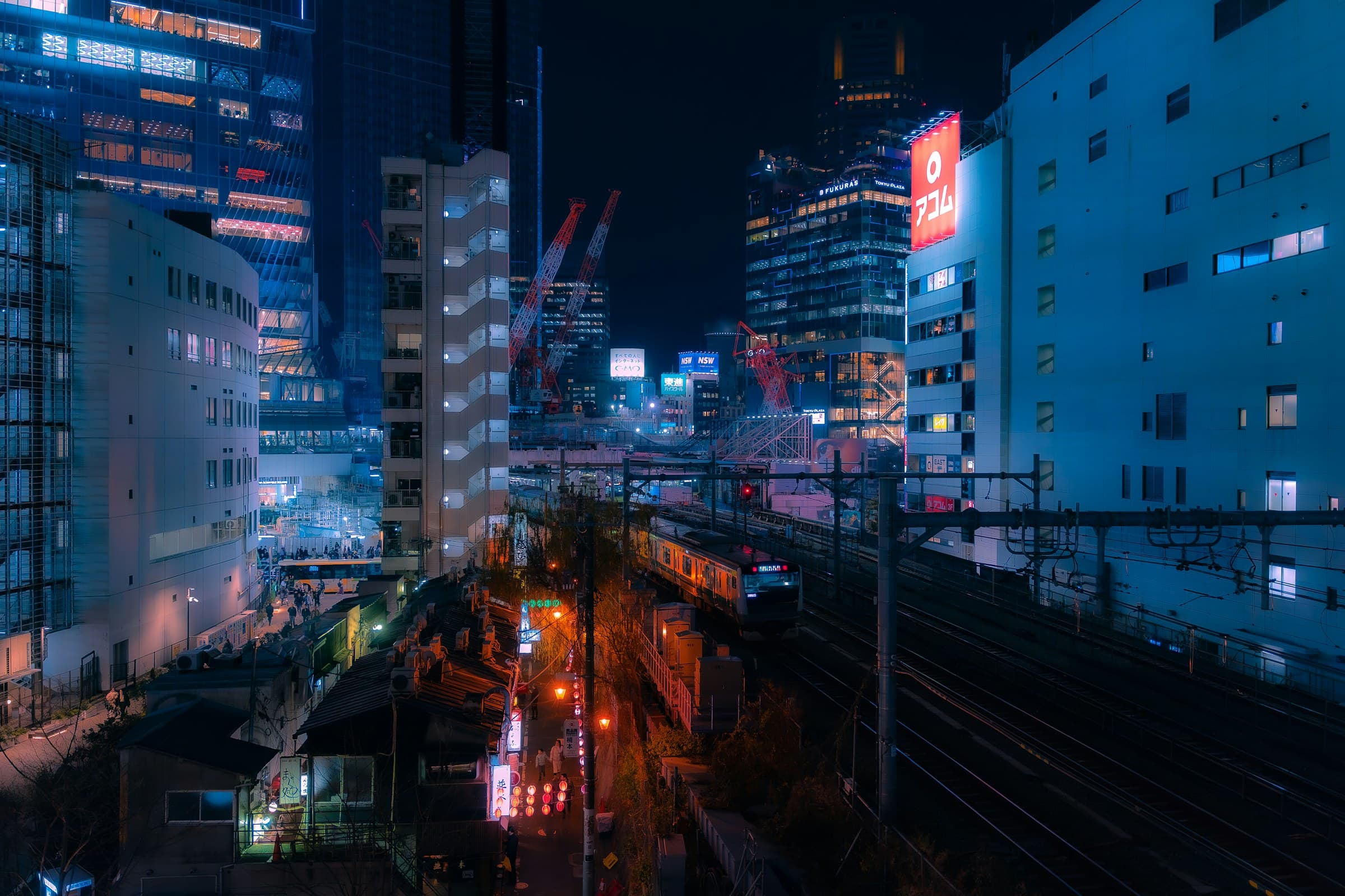A train crossing neon-lit Tokyo at night