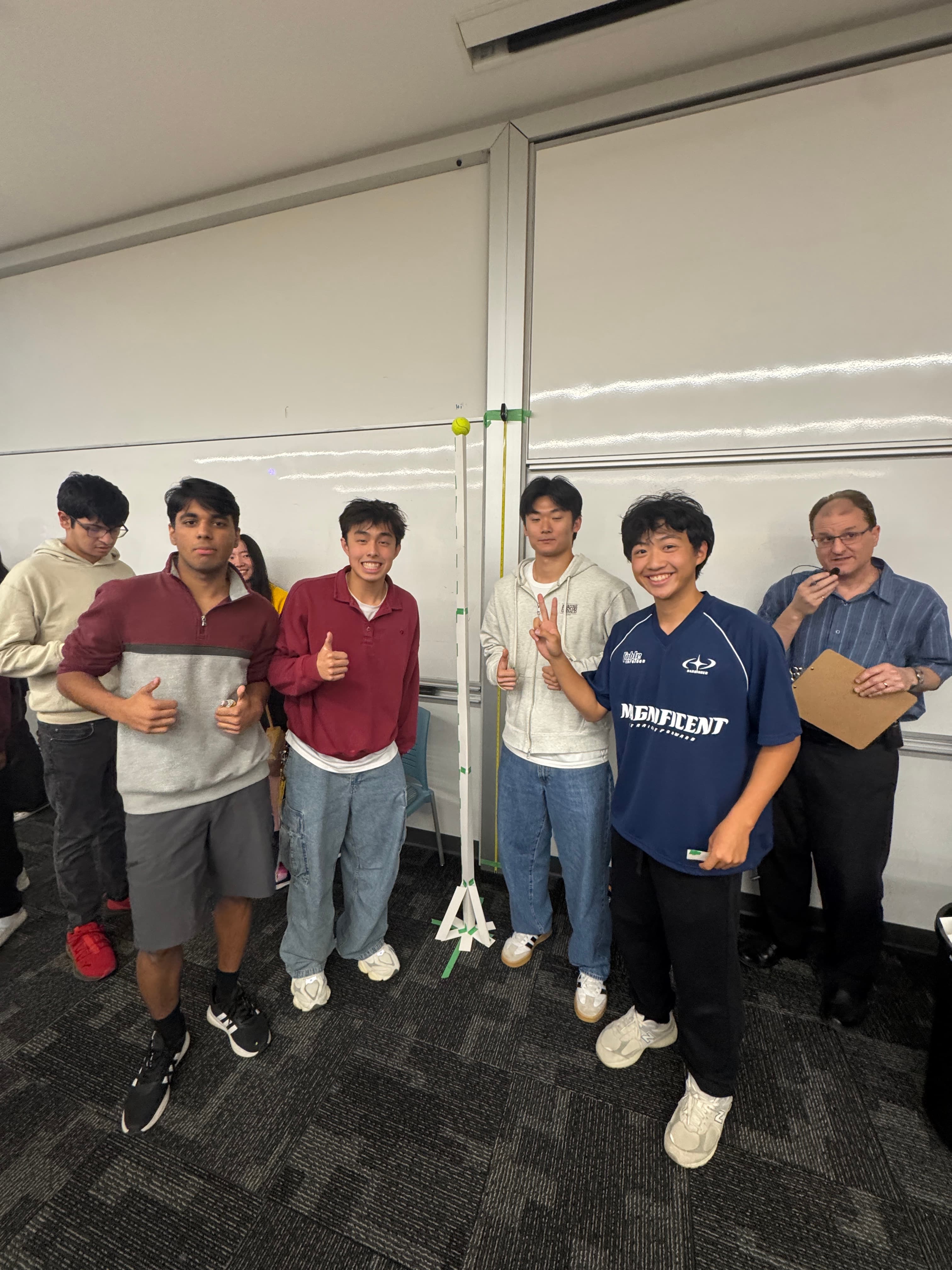 Jaden and classmates with a model tower in an engineering classroom