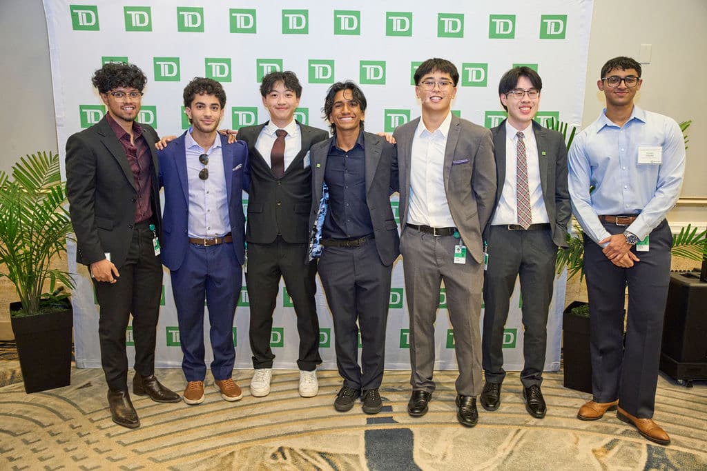 Jaden and fellow TD Bank interns standing in front of a TD backdrop